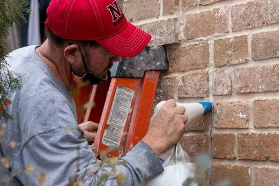 A mason repointing brickwork with fresh mortar